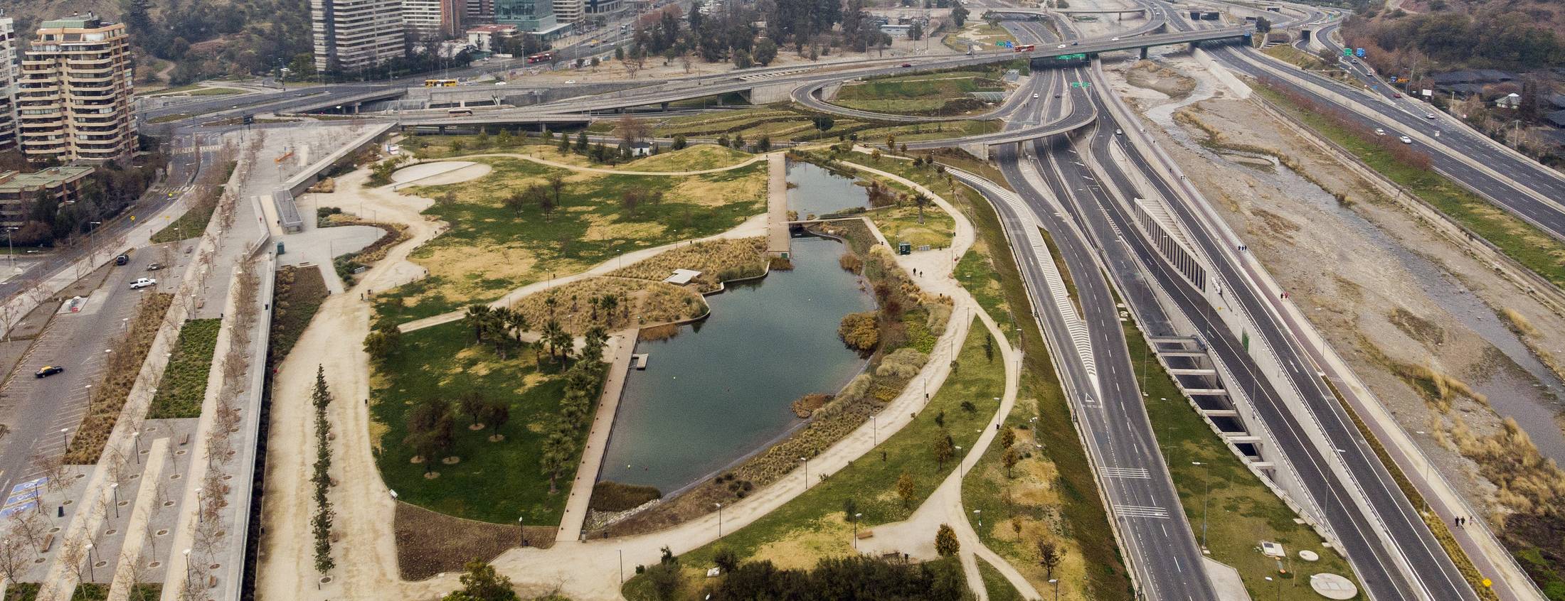 Aerial view of Vitacura's Bicentenario Park, its lagoon and the highways along the Mapocho river, Santiago de Chile